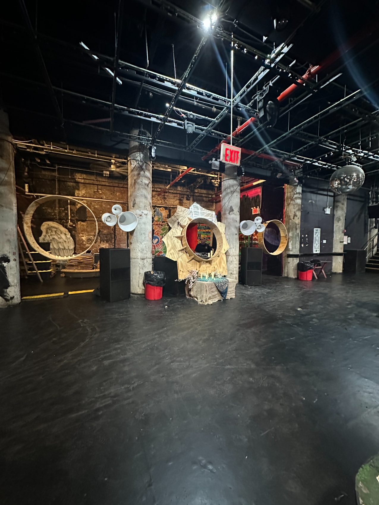 Void horn clusters around a carved wooden DJ booth in a raw, dark Brooklyn venue
